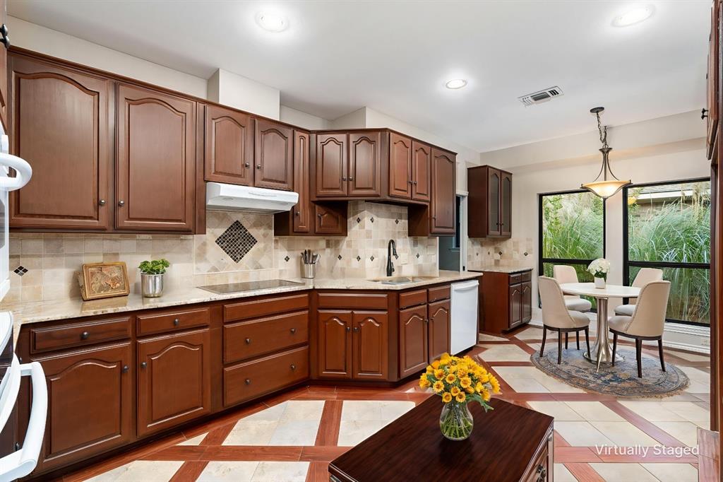 1106 Tahlequah Trail Carrollton, TX 75007 - Photo 7 of 20 a kitchen with stainless steel appliances granite countertop wooden cabinets a dining table and chairs