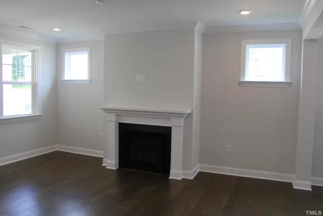 a view of a livingroom with wooden floor and a fireplace