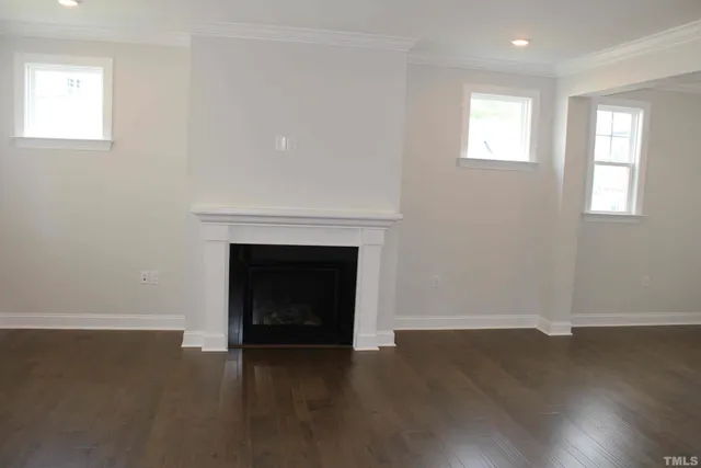 an empty room with a fireplace and windows