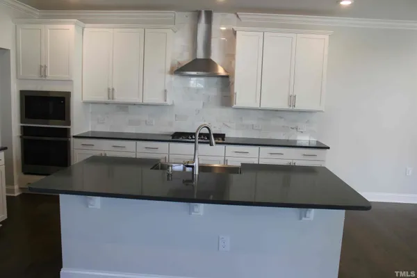 a kitchen with kitchen island a counter top space a sink and stainless steel appliances
