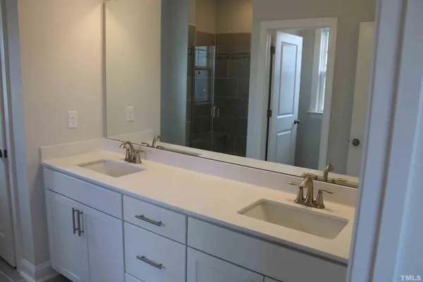 a bathroom with a double vanity sink a mirror and a