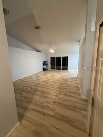a view of an empty room with wooden floor