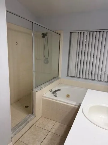 a bathroom with a tub a sink and a shower