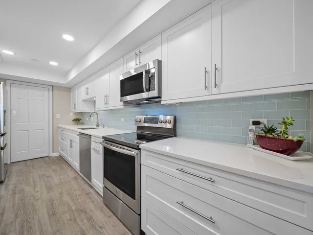 a kitchen with white cabinets and white appliances
