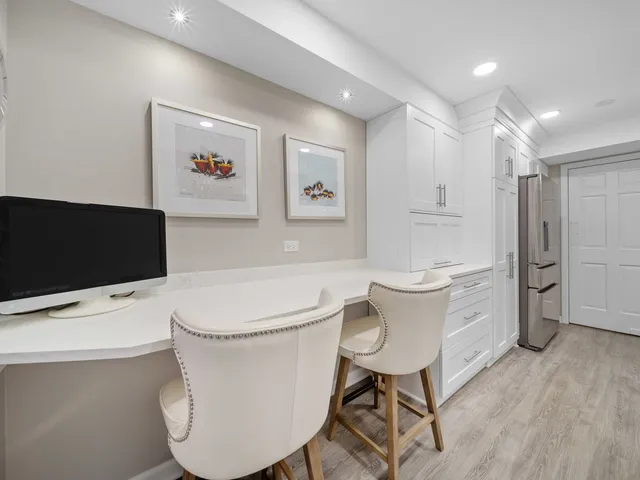 a living room with furniture a flat screen tv and kitchen view