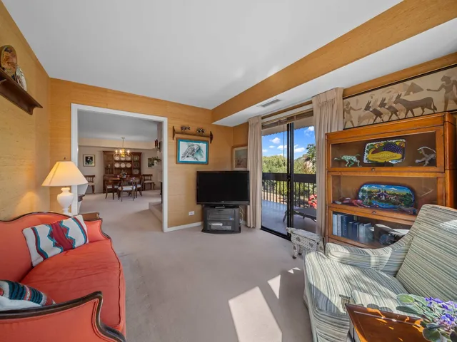 a living room with furniture a flat screen tv and a floor to ceiling window