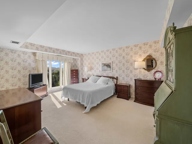 a bedroom with a bed couch and a flat tv screen