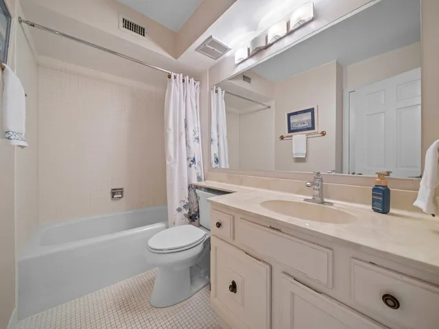 a bathroom with a granite countertop sink a toilet and a bathtub