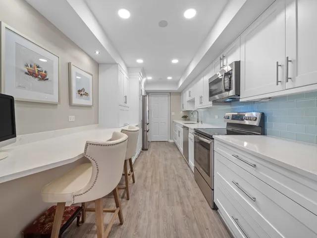 a kitchen with a table chairs refrigerator and cabinets