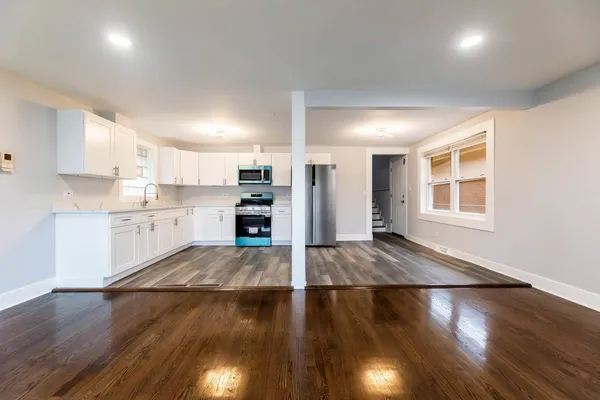 a kitchen with granite countertop a refrigerator and a stove top oven