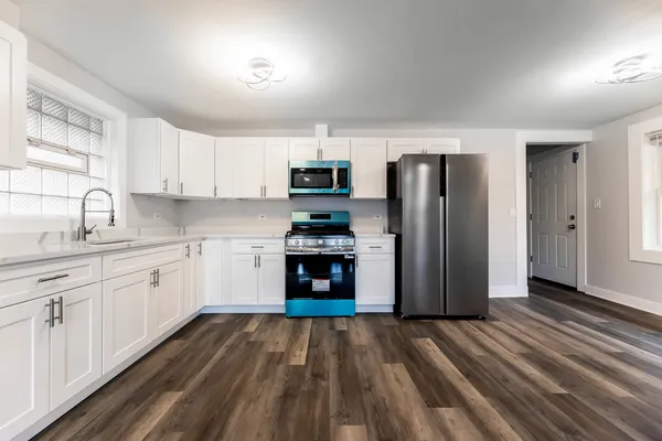a kitchen with white cabinets and stainless steel appliances