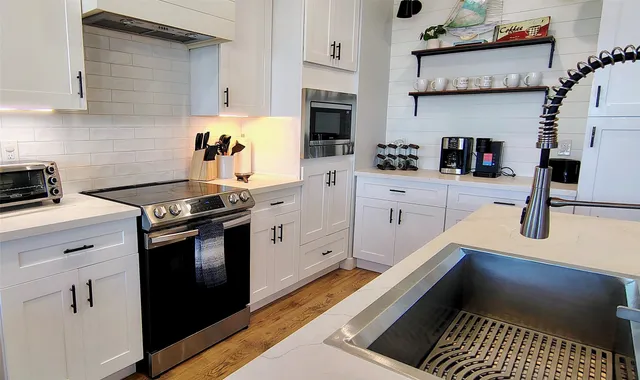a kitchen with stainless steel appliances a stove a sink and a refrigerator