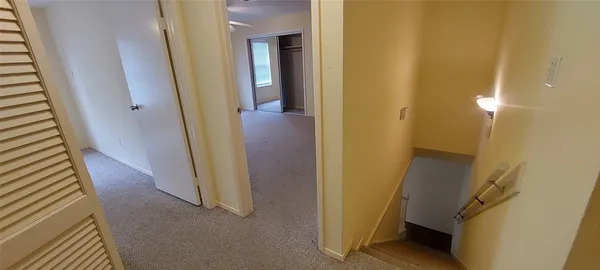 a view of a hallway with wooden floor and staircase