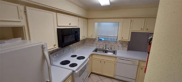a kitchen with a refrigerator and a stove top oven
