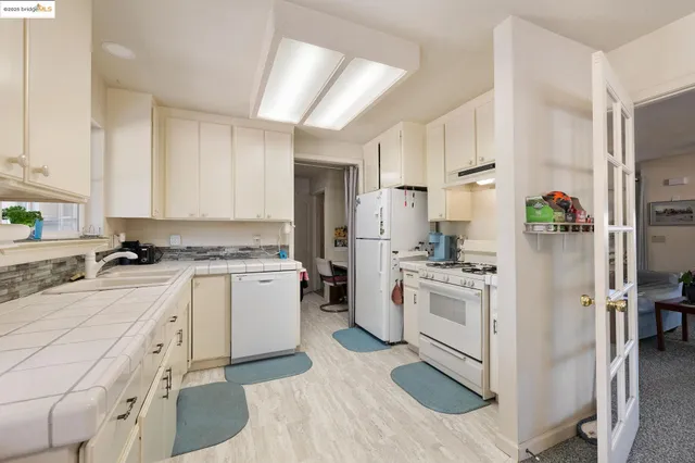 a kitchen with white cabinets and white appliances
