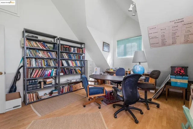 a view of a workspace with furniture and a bookshelf