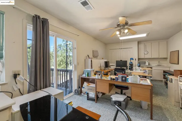 a view of a workspace with furniture and a window
