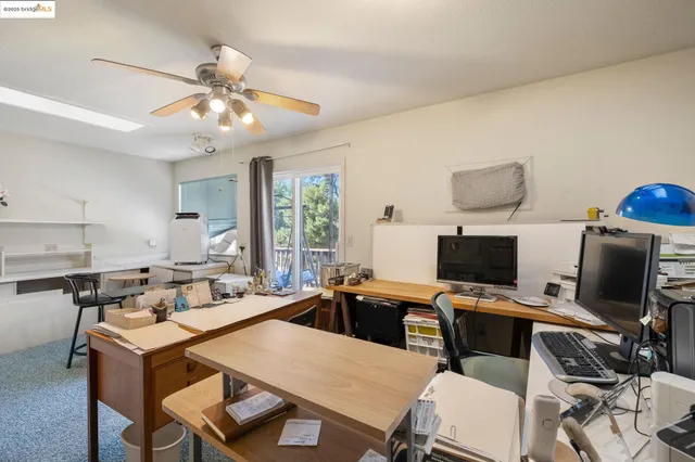a view of a dining room with furniture and a chandelier fan