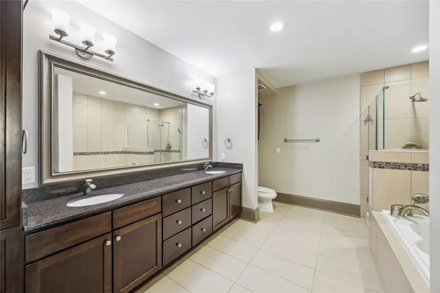 a spacious bathroom with a double vanity sink a large mirror and a bathtub