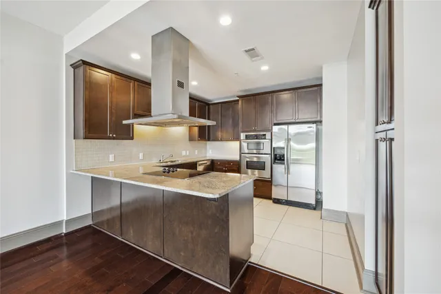 a kitchen with stainless steel appliances granite countertop a stove a sink and a refrigerator