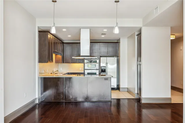 a kitchen with stainless steel appliances granite countertop a sink a refrigerator and a stove