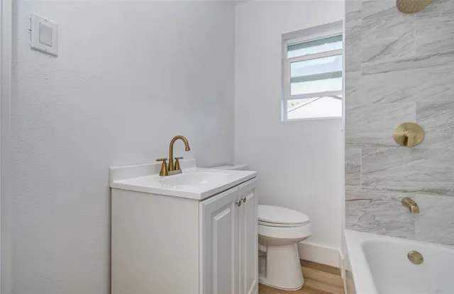 a bathroom with a sink toilet and window