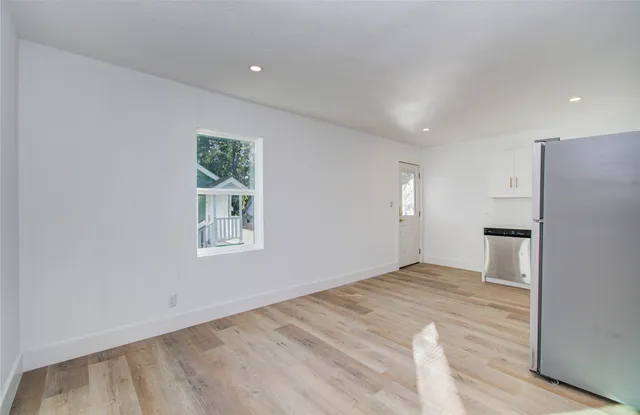 a view of empty room with window and wooden floor