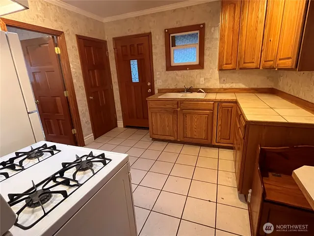 a kitchen with a stove a sink and a refrigerator