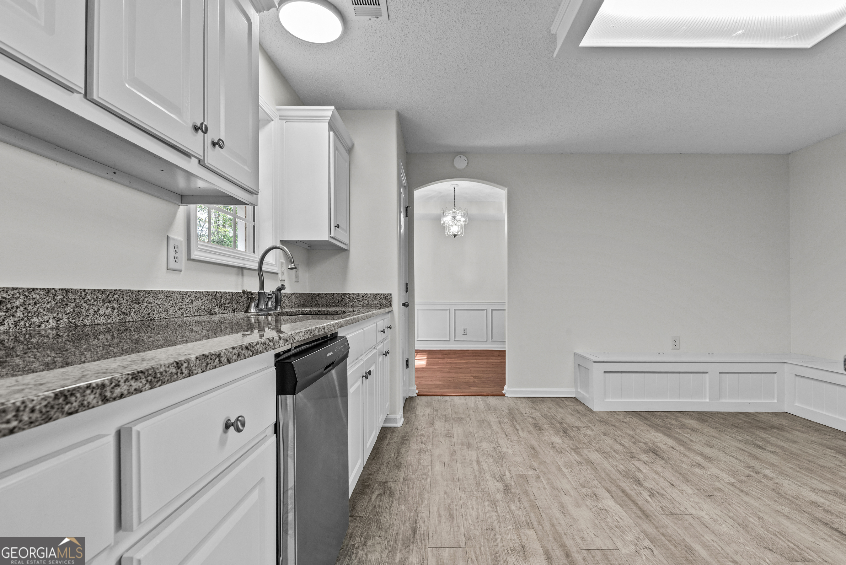 427 Bridges Way Winterville, GA 30683 - Photo 19 of 43 a kitchen with a sink dishwasher a stove and white cabinets with wooden floor
