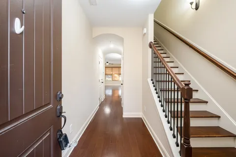 a view of a hallway with wooden floor and staircase
