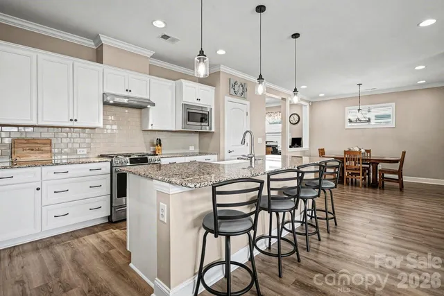 a large kitchen with cabinets table and chairs