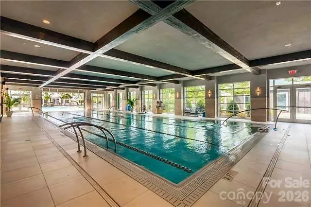 a swimming pool with large glass windows and painted walls