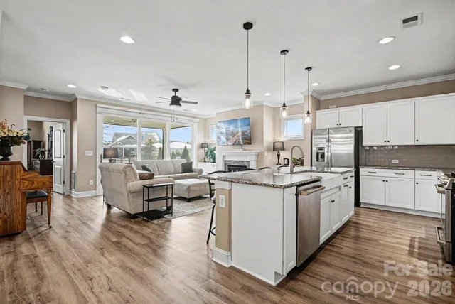 a large kitchen with stainless steel appliances kitchen island granite countertop a large center island attached withe living room