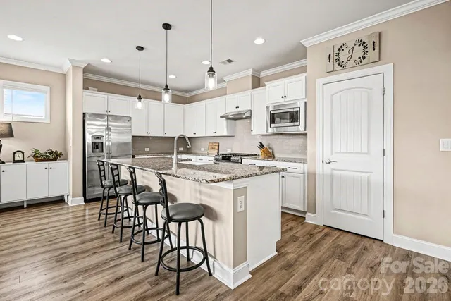 a kitchen with kitchen island granite countertop a sink cabinets and wooden floor