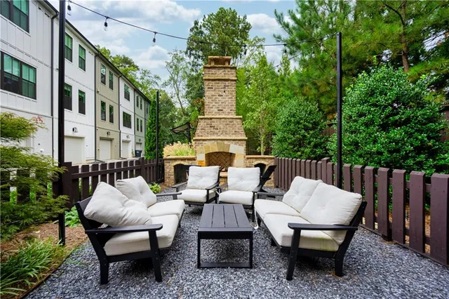 a view of a patio with couches table and chairs and wooden fence