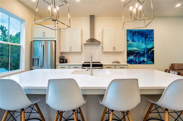 a kitchen with stainless steel appliances a table chairs and a refrigerator