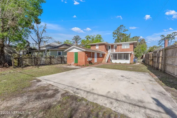 a front view of a house with a yard and trees