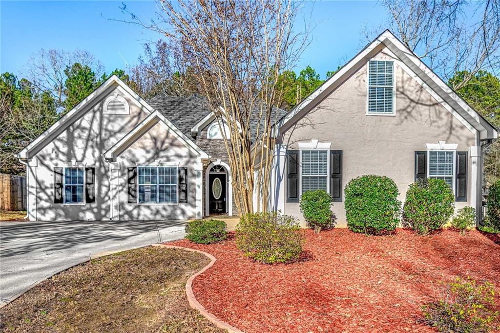 a front view of a house with a yard and potted plants