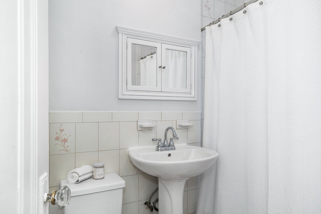 8 Kinross Road, Unit 4 Boston, MA 02135 - Photo 9 of 13 a bathroom with a sink a toilet and mirror