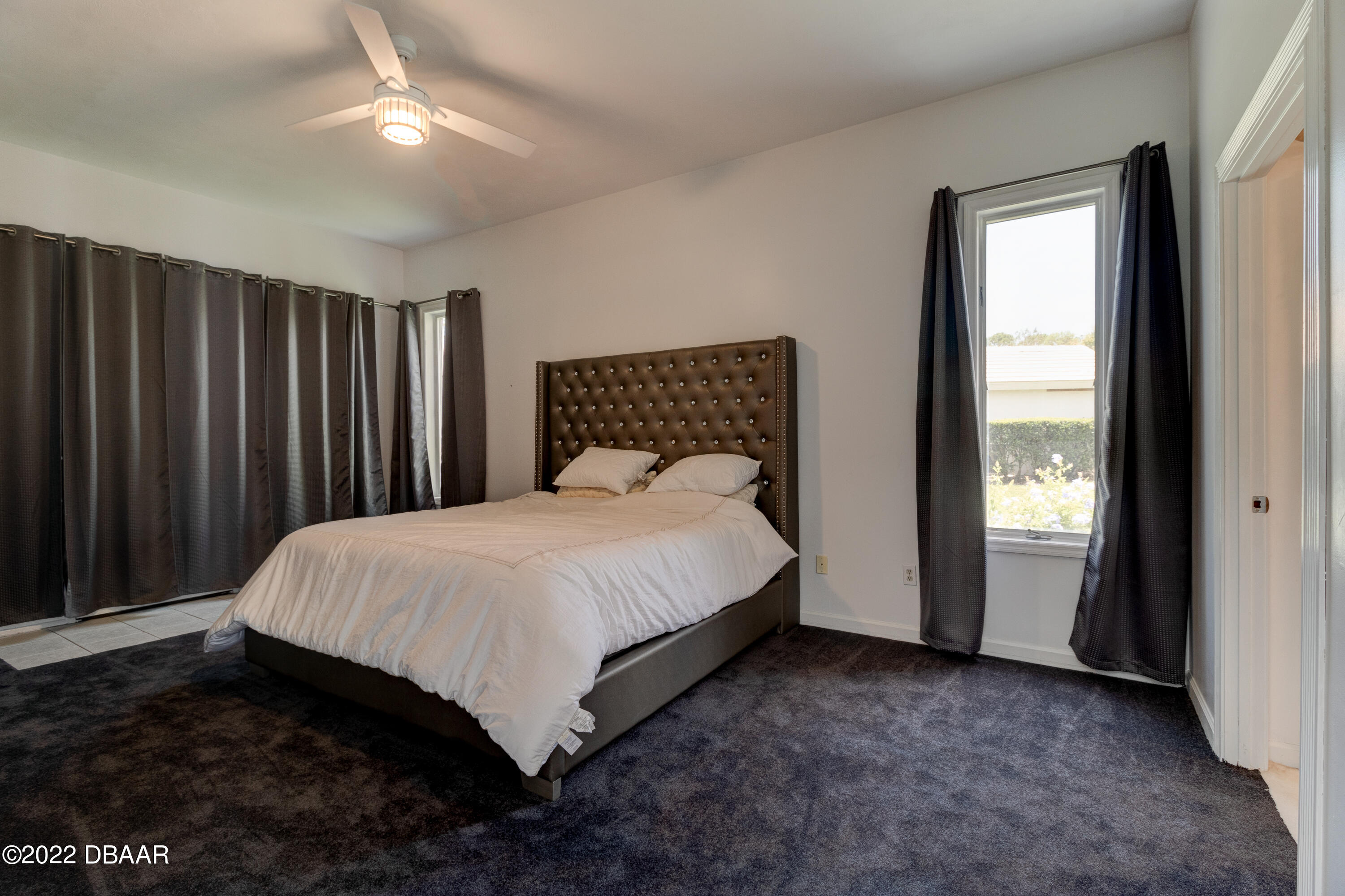 13 Bay Pointe Drive Ormond Beach, FL 32174 - Photo 18 of 44 a bed sitting in a spacious bedroom next to a window and a mirror