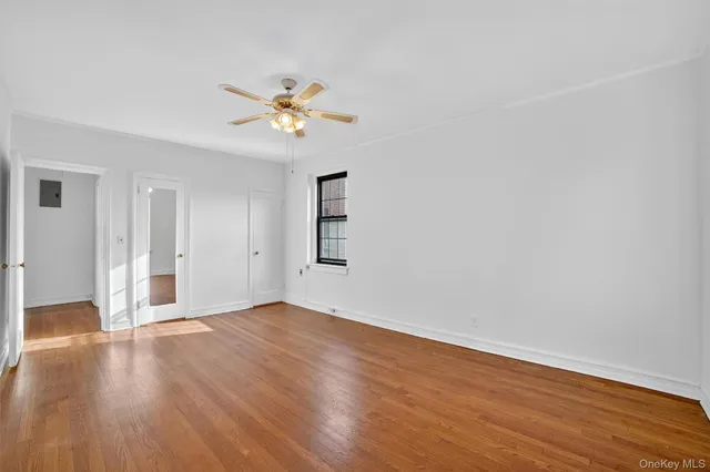 a view of a big room with wooden floor and windows in a room