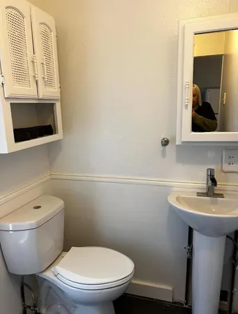 a bathroom with a toilet a sink and mirror