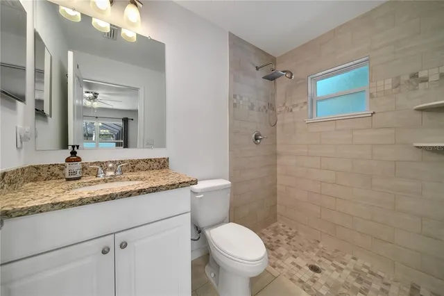a bathroom with a granite countertop sink toilet and shower