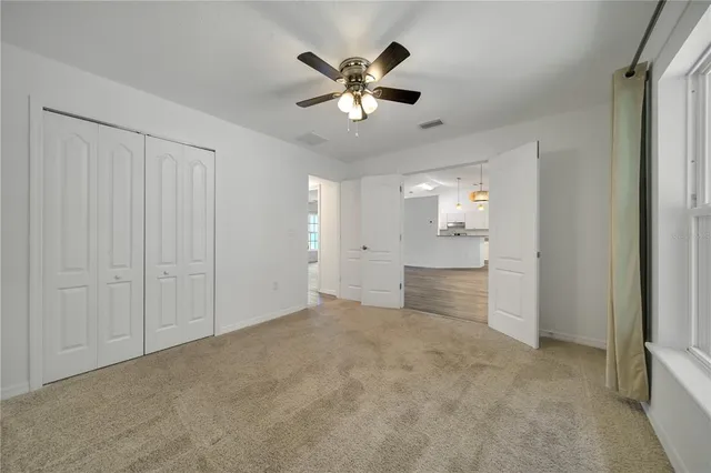 a view of an empty room and kitchen view