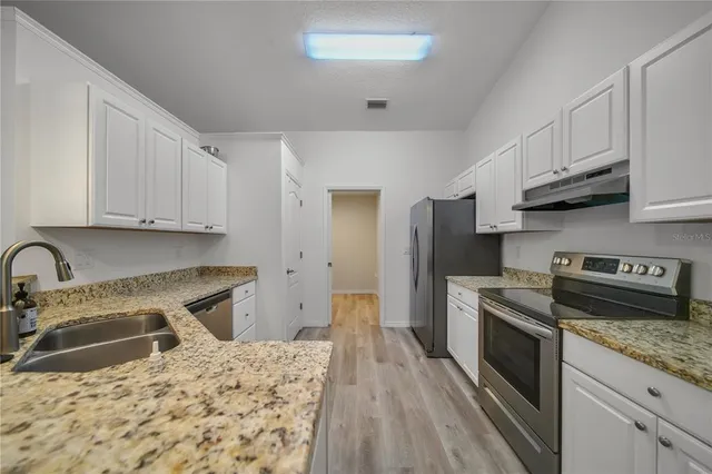 a kitchen with a sink stove and refrigerator