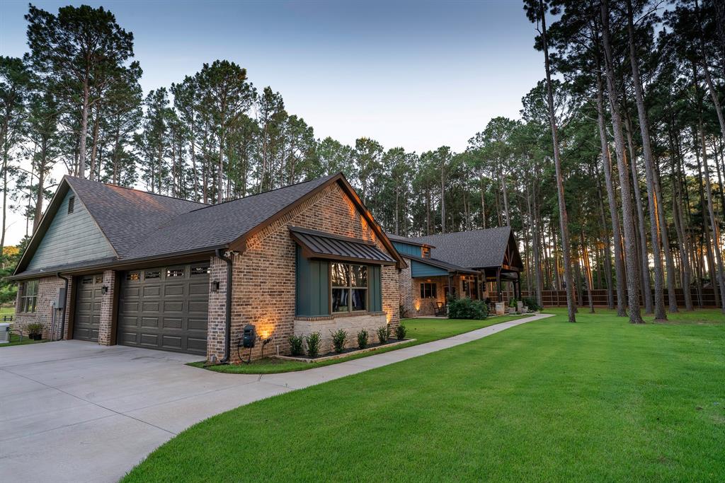 8595 Toler Pointe Larue, TX 75770 - Photo 4 of 40 The golden sun in the late afternoon cast a golden glow on the pines. This is a view of the oversized 35'x23' car garage with a motor court with 3 parking spaces, but the driveway can hold many more.