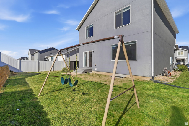 1177 South Raintree Lane Santaquin, UT 84655 - Photo 24 of 25 Expansive grassy yard area with a white privacy fence and a rear deck with sliding glass door access