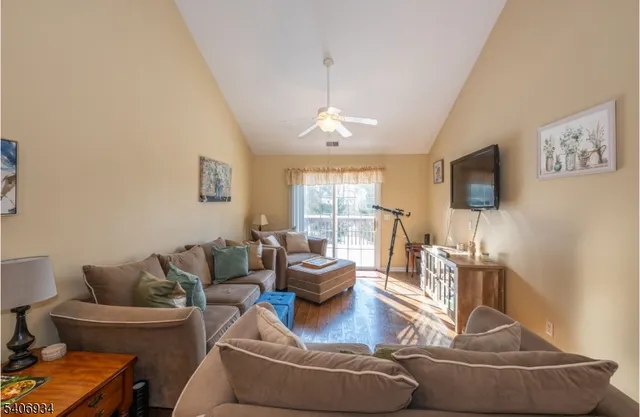 a living room with furniture a flat screen tv and a window