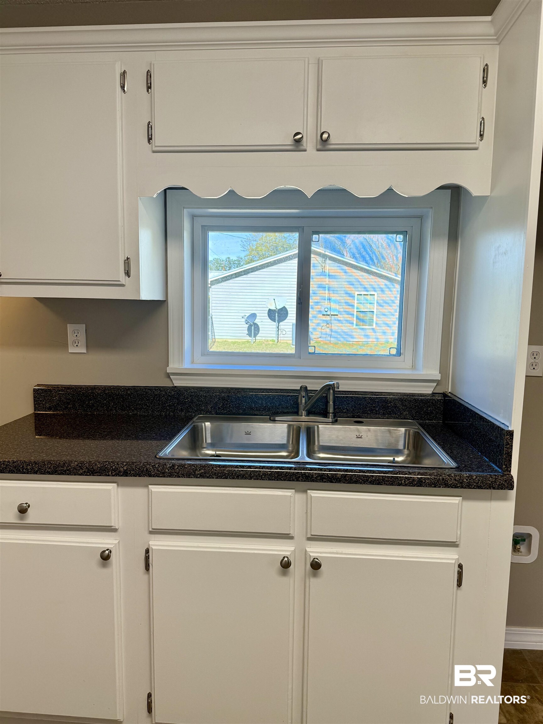 205 Schad Street Brewton, AL 36426 - Photo 7 of 11 Kitchen with dark countertops and white cabinets