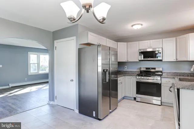 a kitchen with stainless steel appliances granite countertop a refrigerator a stove a sink and a sink